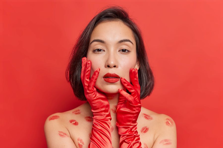 woman with red lipstick and red gloves looks into camera