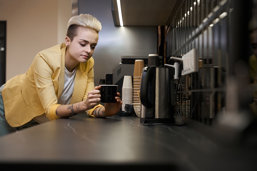 Woman operating office coffee machine