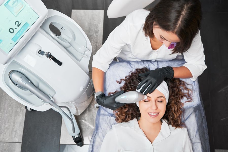 woman gets laser aesthetic treatment in clinic