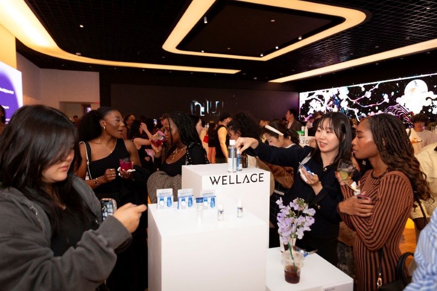 Girls crowded around a stand of skin care.