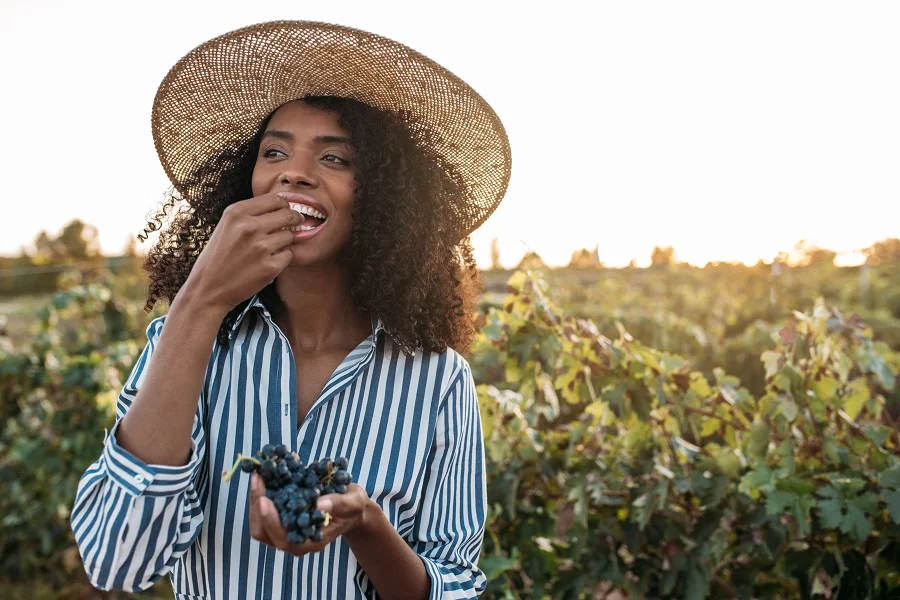Woman eating grapes in a vinyard
