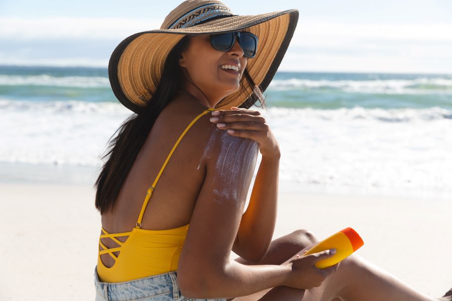 Woman applying sunscreen on the beach