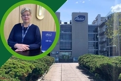 Valio video thumbnail: Woman wearing a Valio lanyard seated beside Valio branding, with a Valio office building and landscaped entrance in the background Valio video thumbnail: Woman wearing a Valio lanyard seated beside Valio branding, with a Valio office building and landscaped entrance in the background