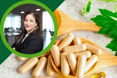Image Woman in business attire beside herbal supplement capsules on a wooden spoon with fresh green leaves.
