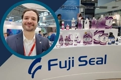 Interpack 2026 Fuji Seal: Fuji Seal trade show booth displaying branded packaging samples, with an inset portrait of a company representative Interpack 2026 Fuji Seal: Fuji Seal trade show booth displaying branded packaging samples, with an inset portrait of a company representative