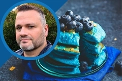 Oterra video thumbnail: Blue pancakes topped with blueberries beside a circular portrait of a man on a blue graphic background Oterra video thumbnail: Blue pancakes topped with blueberries beside a circular portrait of a man on a blue graphic background
